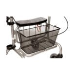 Human Care Basket for Parade Rollator — black fine-mesh trapezoid rollator basket mounted under the silver Parade rollator seat, narrower at the bottom than the top to follow the angled rollator frame