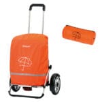 Andersen Rain Cover for Shopping Trolley — bright orange waterproof rain cover with reflective horizontal trim pulled over a shopping trolley with two large black wheels, shown beside the matching orange compact roll bag for storage