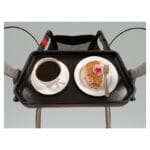 Rehasense Tray for Server and Athlon — black rectangular plastic tray with high edges resting on a rollator seat between the handle bars, with a coffee cup and a plate with a pastry on top