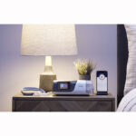 AirSense 11 on bedside table with nasal mask and myAir app on phone