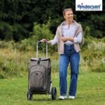 Woman pulling the olive Andersen Royal Hydro 3.0 trolley across a lawn