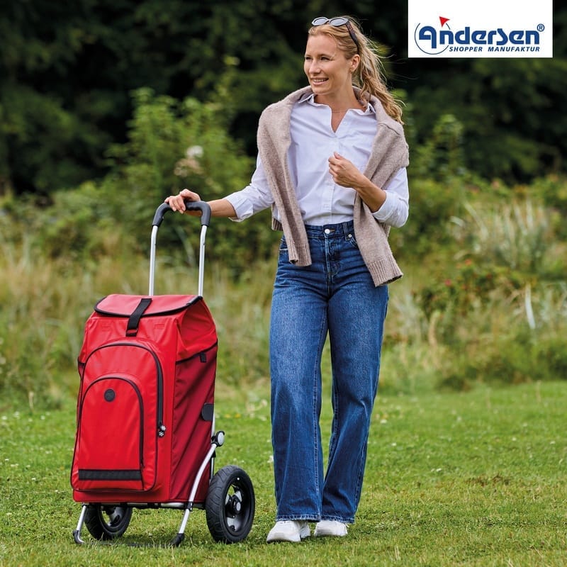 Woman pulling the red Andersen Royal Hydro 3.0 trolley across a lawn