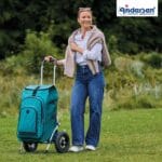Woman pulling the petrol Andersen Royal Hydro 3.0 trolley across a lawn