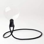 Round RBP neck magnifier lens on a long black bendable strap curled on a white surface