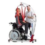 Carer using a Molift Smart 150 lift to move a woman in the RgoSling from a wheelchair