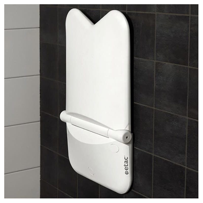 Etac Relax shower seat folded up flat against a dark tiled wall