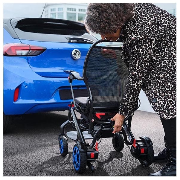 Woman folding the Q50 R Carbon down beside a blue car