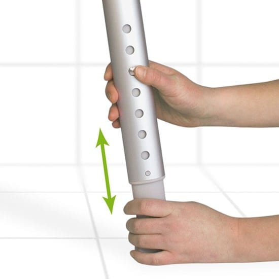 Two hands adjusting a telescopic stool leg with a row of height holes