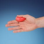 Red putty flattened in an open palm