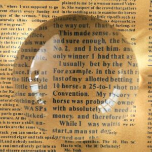 The stone on a newspaper page with the text under the dome magnified