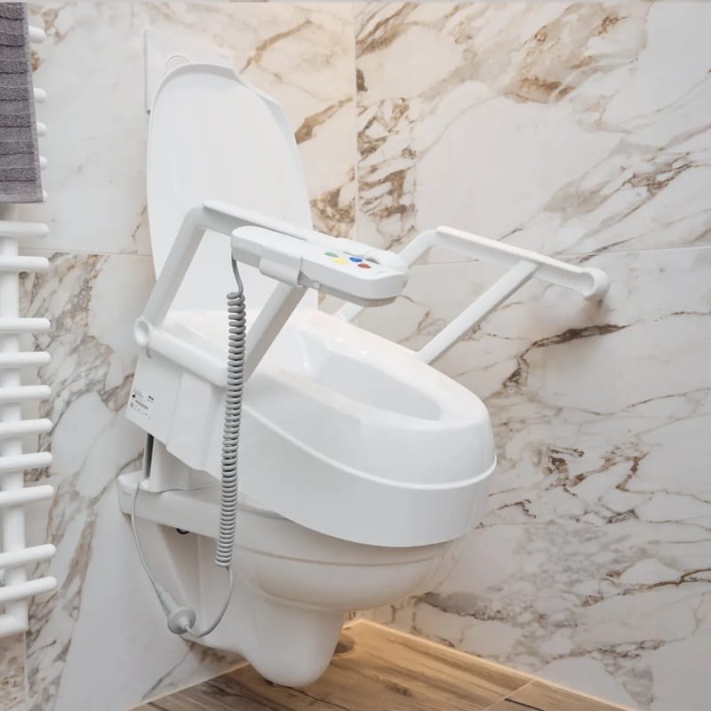 White toilet seat with armrests fitted on a wall-hung toilet