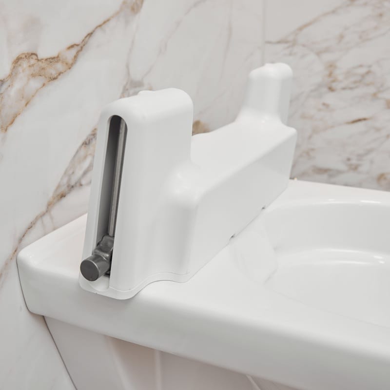 Close-up of the white drive unit with lifting arm at the back of the toilet
