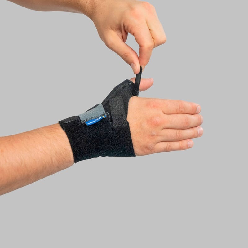 Fingers adjusting the Velcro tab at the thumb section