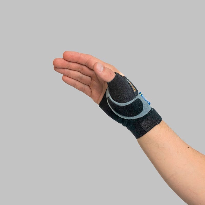 The brace in profile with the hand slightly bent and the strap tight over the thumb base